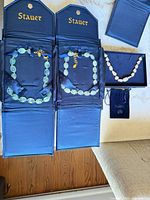 Overview of three necklaces in Stauer cases and pouch