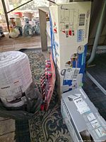 Boxed Bissell steam mop, boxed Rowenta iron, packaged Husky screwdriver set, packaged Sonoma quilt grouped together