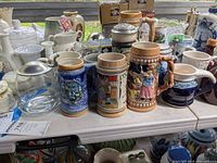 Front view showing multiple steins and jugs on table