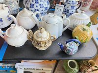 All seven assorted teapots on table