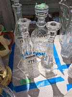 Two faceted crystal candlesticks with hexagonal bases among other glassware