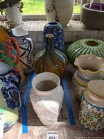 Group shot showing three vases within taped boundary