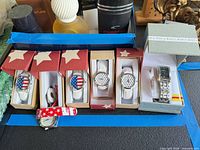 Six watches in boxes showing dial designs and Apt 9 watch
