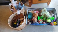 Two wicker baskets and one fabric basket filled with assorted dog toys