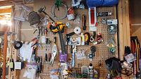 Pegboard view showing assorted hand tools, tape measures, knives, lubricant, packs of screws and anchors