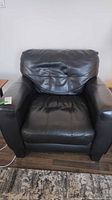 Front view of black faux leather armchair