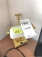 Front view of brass banker desk lamp showing white glass shade and overall design