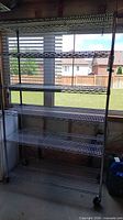 Full view of assembled chrome wire shelving unit with six shelves and casters