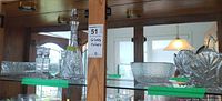 Shelf view showing decanter, candlesticks, bowls, trays