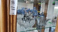 Shelf showing beaded tree, cut crystal bowls, pressed glass serving piece