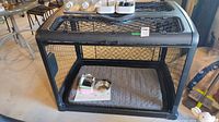Overall view of dog crate with mat and bowls