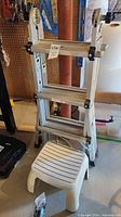 Ladder folded with plastic step stool in front