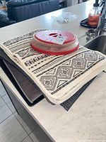 Stacked patterned drying mats with silicone mat beneath and microwave cover on top