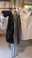 Hangers, garment bags and bedspread displayed on rack