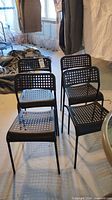 all four black perforated chairs front view