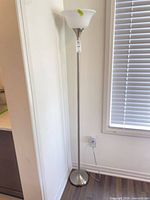 Full view of brushed nickel floor lamp with white torchiere shade