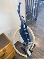 Full view of Royal upright vacuum with hose wrapped around unit