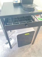 Full view of black metal coffee table, drawer open