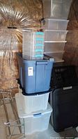 overall view of stacked storage totes, clear drawers, nested bins, folding crate and metal rack