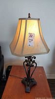 Full view of lamp showing metal base, shade, finial, cord