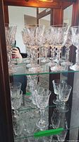 Multiple shelves showing tall and small cut crystal stemware pieces