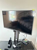 Front view of Vizio V405-G9 TV on stand, remotes and power cord visible