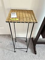 Full view of plant stand showing wicker top and metal frame