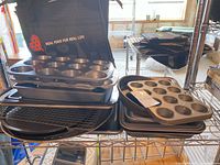 Stack of muffin pans, sheet pans, cooling rack on shelving unit
