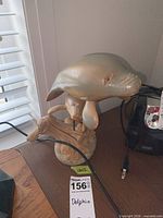 Full view of wood dolphin on stone/composite base