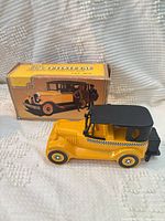 Cab-shaped decanter beside original box, front angle