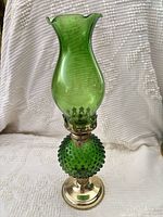 Full view showing green glass chimney, hobnail font, brass burner and base