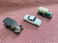 Three diecast cars arranged on red check fabric