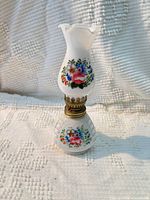 Full view of milk glass miniature oil lamp with floral decals and brass burner