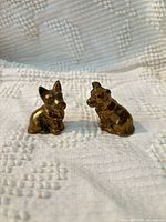 Front view of both brass dog figurines