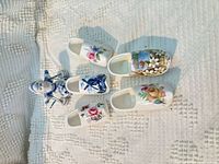 Five decorated porcelain miniature clogs laid out, top view
