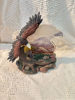 Front view of eagle figurine showing tree stump, foliage and frosted backdrop