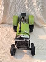 Front view of green metal tractor model showing grille, exhaust stack and front wheels