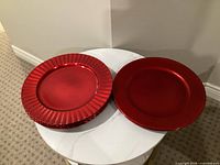 Stack of ribbed rim plates beside stack of beaded rim plates