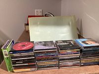 Two stacks of audio CDs showing jewel cases and cardboard sleeve, approximately 55 discs visible
