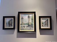 Three framed Paris oil paintings on wall