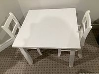 Overhead view of white square toddler table and two chairs