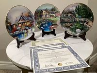 All three collector plates on stands with certificates visible