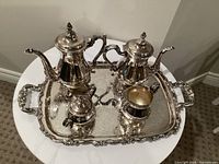 Full view of five-piece silver-plated service set on tray