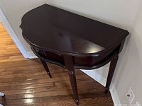 Full view of front and top of demilune console table