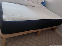 Side view of mattress on wood frame