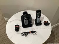 Full lot overview: base with handset, second handset on cradle, two power adapters, phone line cord