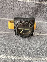 Front view of Suunto wrist compass showing dial, bezel, and yellow strap