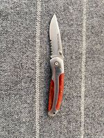 Knife fully open showing blade inscription and wood handle