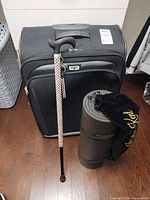 Front view of suitcase, cane, mat and velvet bag
