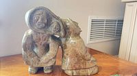 Front view of polished stone sculpture showing two Inuit figures